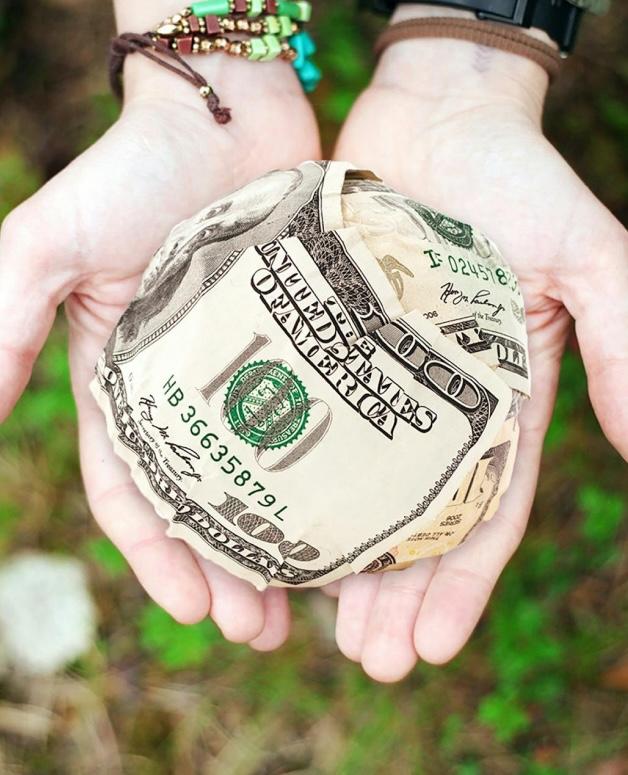 A person holding a dollar bill in their hands.