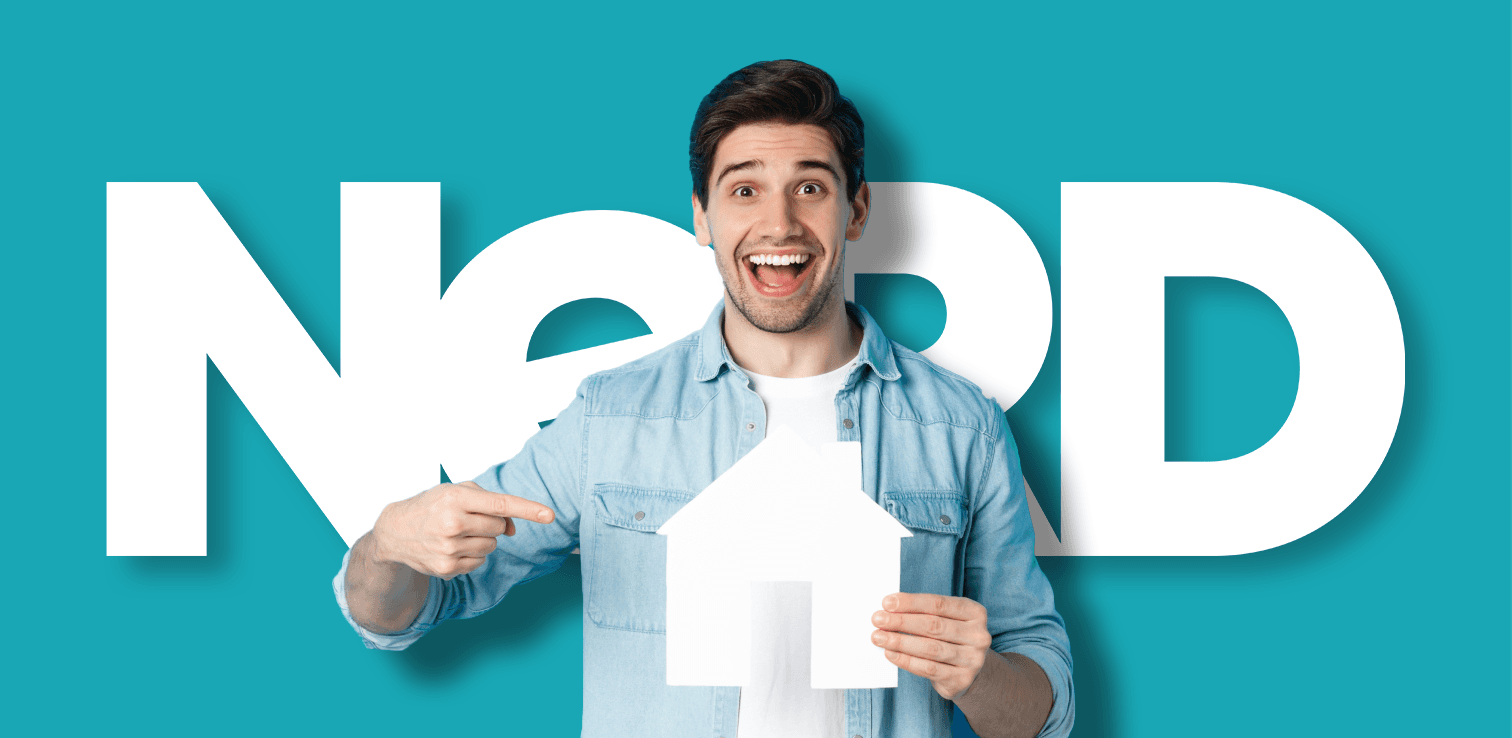 A man in a blue shirt holding a white cutout in the shape of a house, behind him the word 'Nerd' is printed in large text